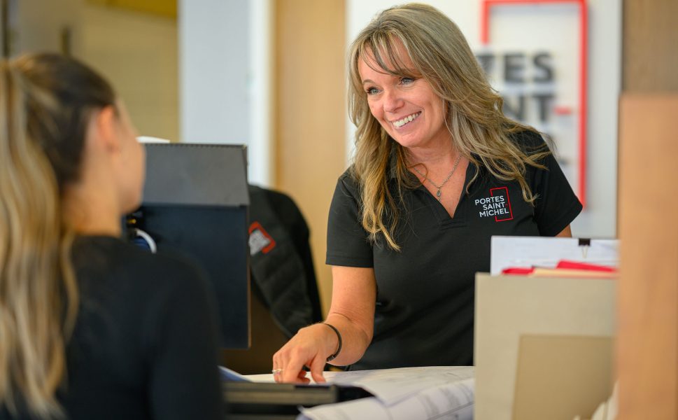 Customer service advisor at Portes Saint-Michel welcoming a client with a smile