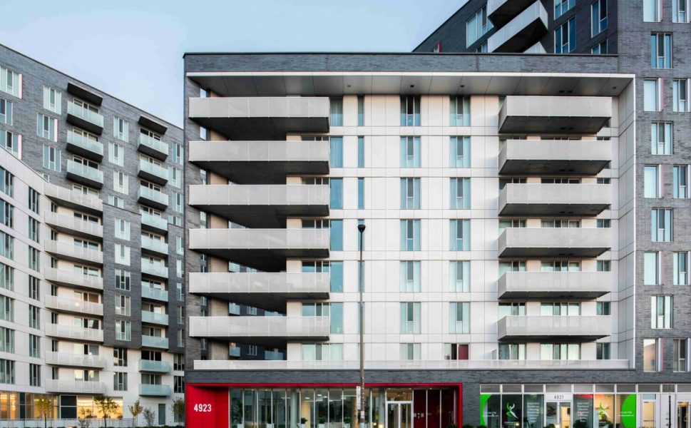 Facade of a modern residential building with balconies and main entrance at 4923 in Laval