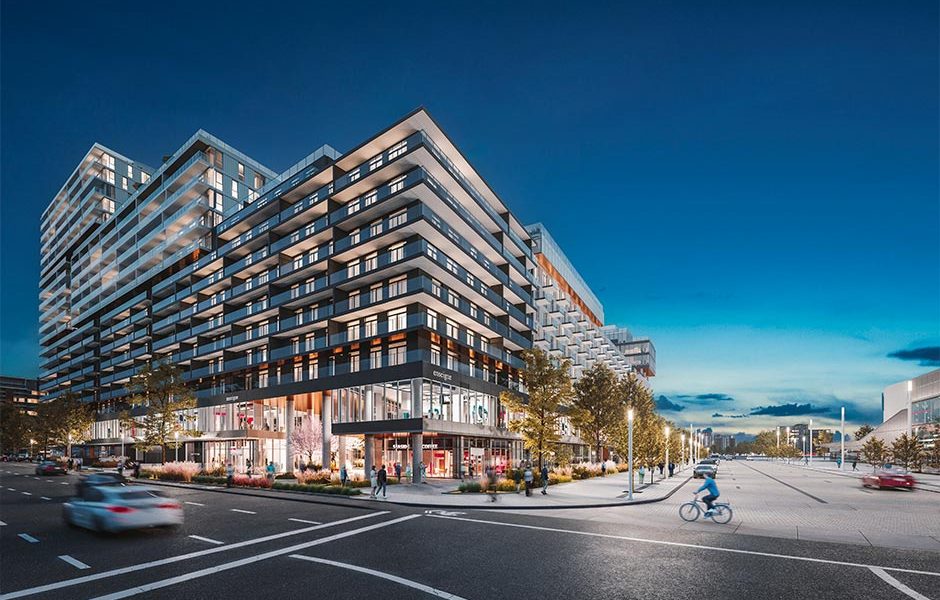 Night view of Espace Montmorency real estate project in Laval with modern shops and apartments