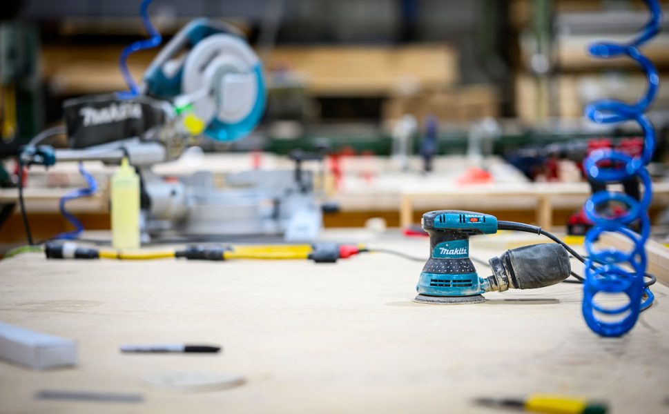 Atelier de menuiserie Portes Saint-Michel avec outils de fabrication et ponceuse Makita